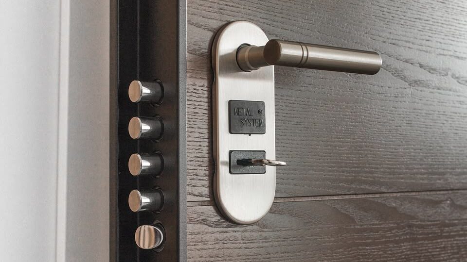 Locked front door with a key inserted into the deadbolt.